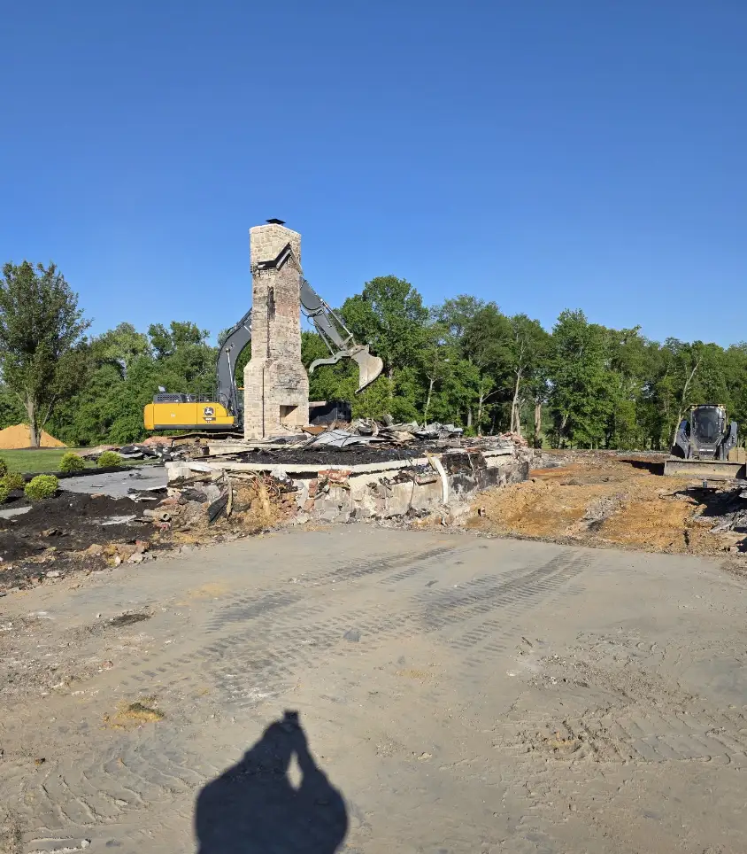 Excavator and chimney on a cleared demolition site