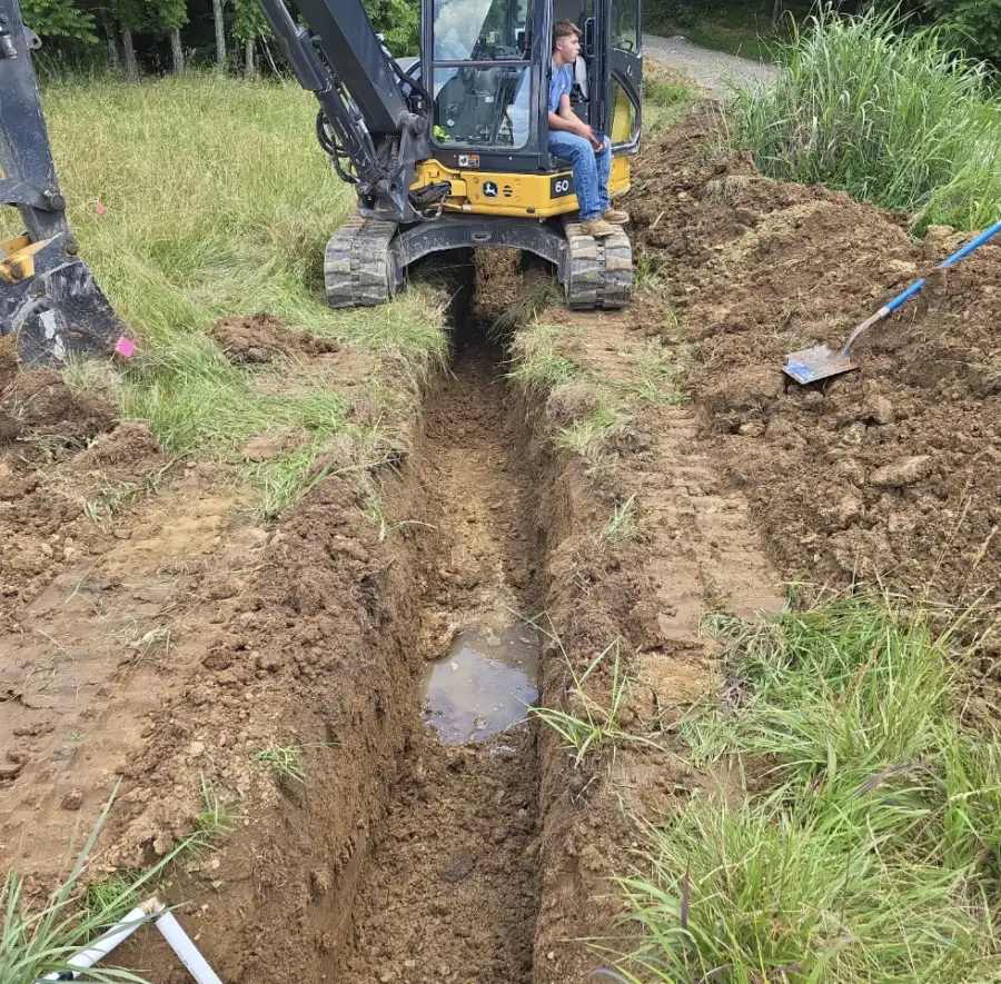 Mini excavator digging a trench for a water line